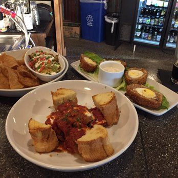 A table topped with plates of food and a bowl of chips.