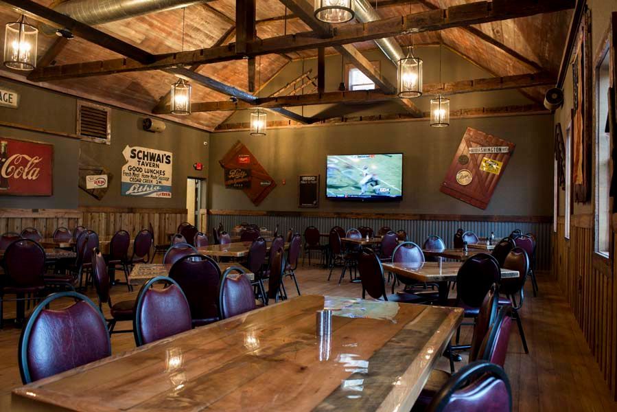 A large dining room with tables and chairs and a coca cola sign on the wall.