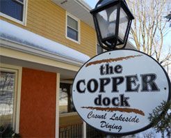 A sign for the copper dock casual lakeside dining is outside of a building.