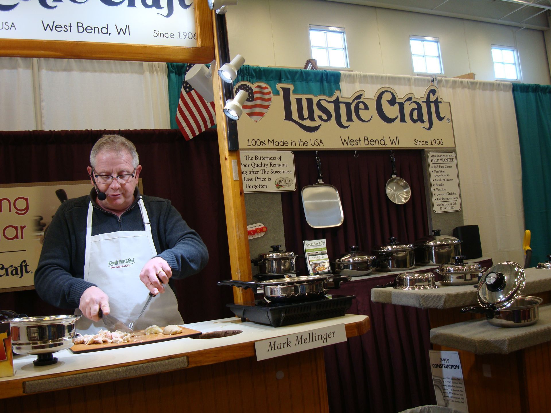 A man cooking in front of a sign that says lustre craft