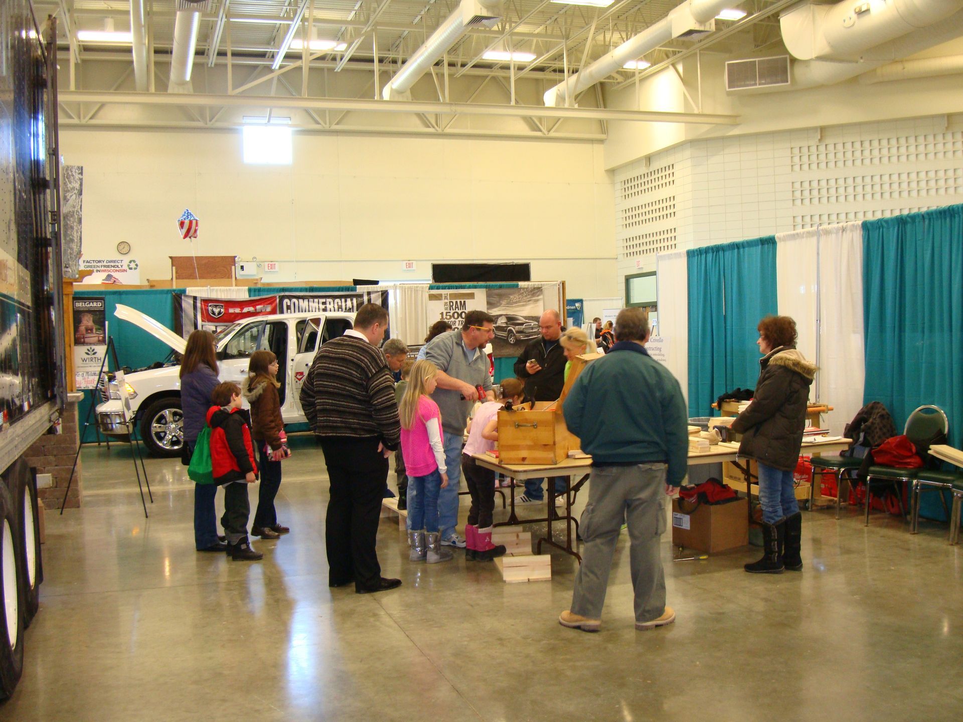 A group of people standing in a room with a truck in the background