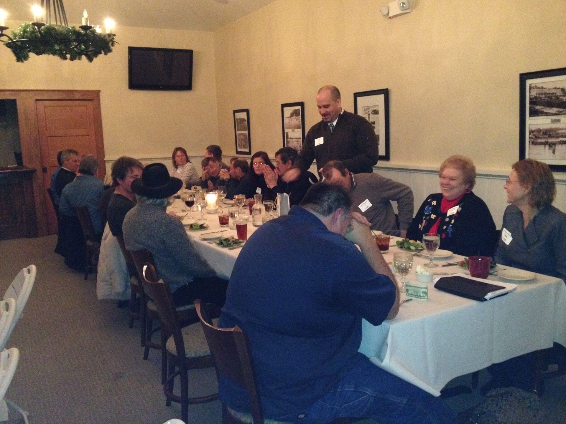 A group of people are sitting at a long table