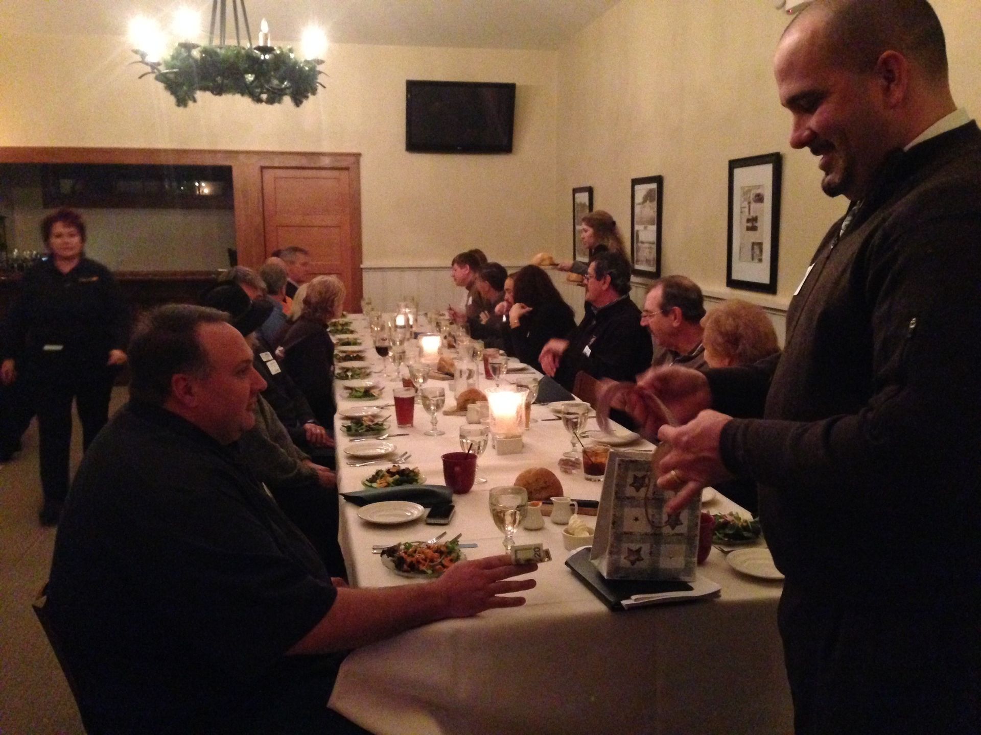 A group of people are sitting at a long table