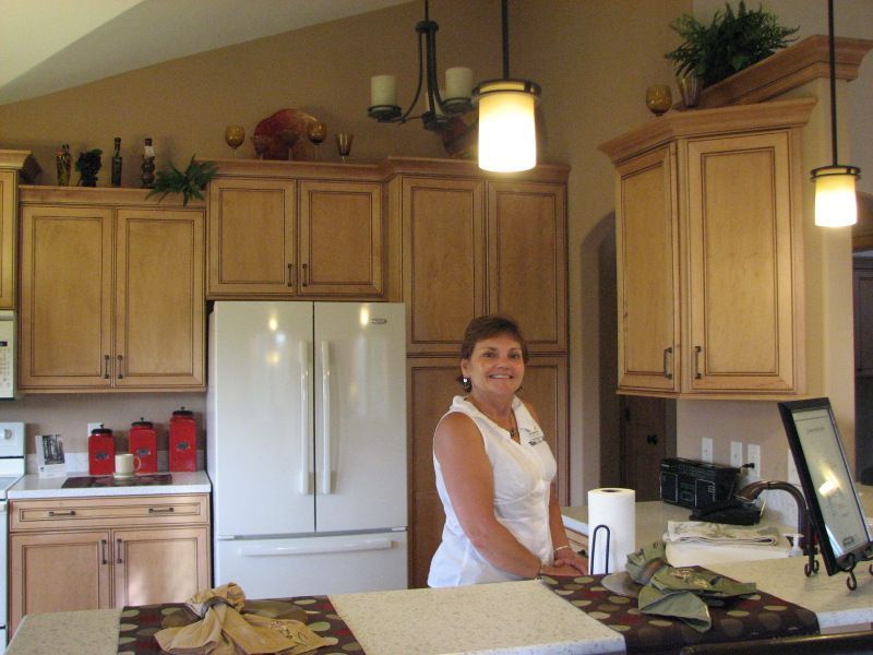 A woman is standing in a kitchen next to a refrigerator