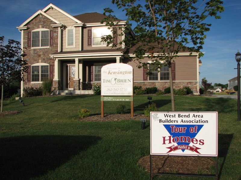 A house with a sign in front of it that says tour of homes