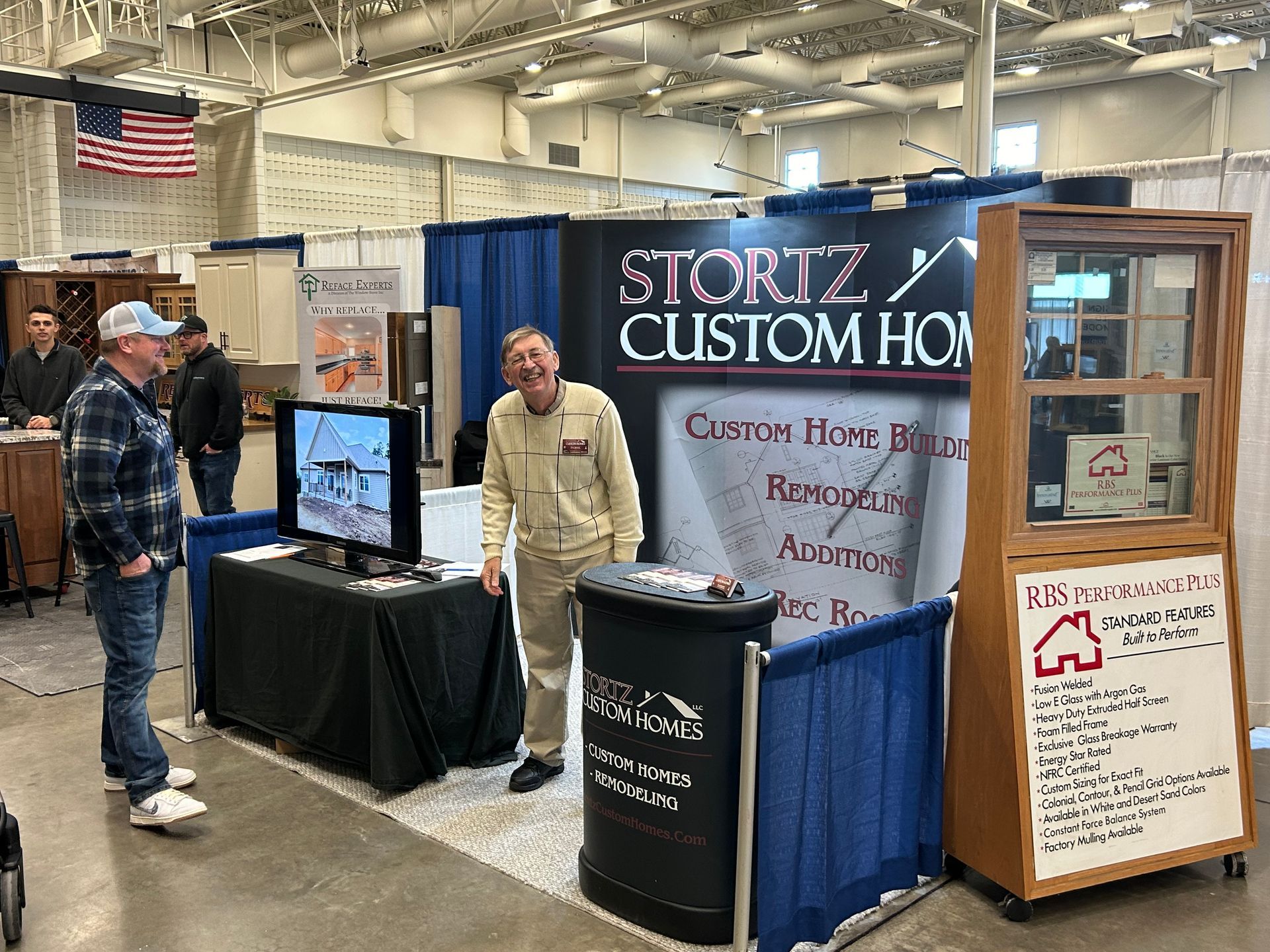 A man is standing in front of a booth for stortz custom homes.