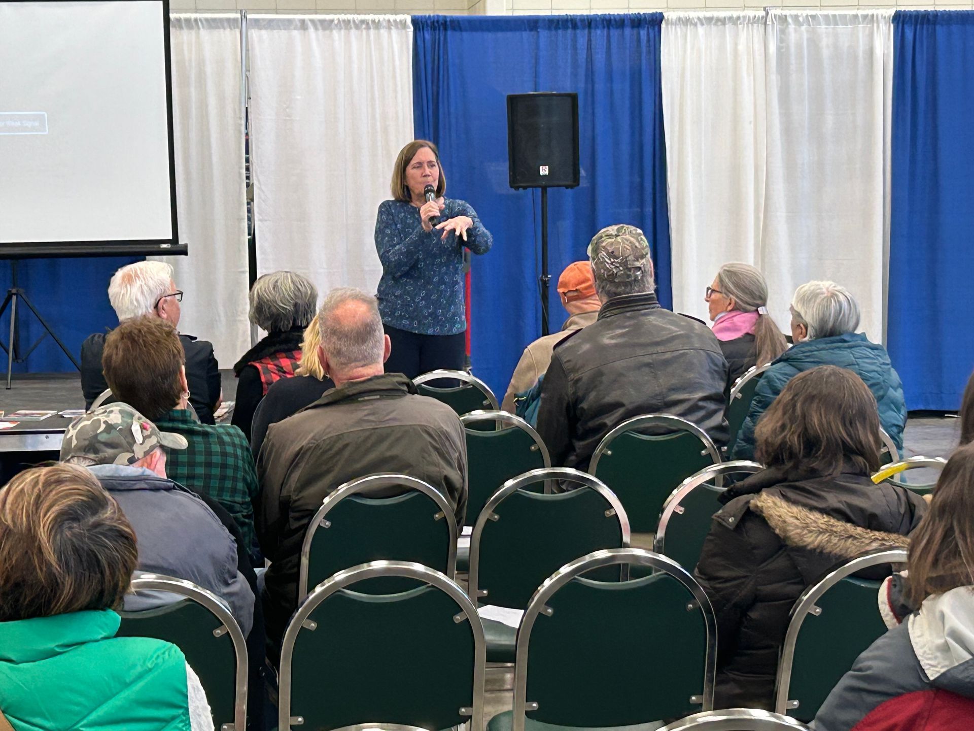 A woman is giving a presentation to a group of people in a conference room.