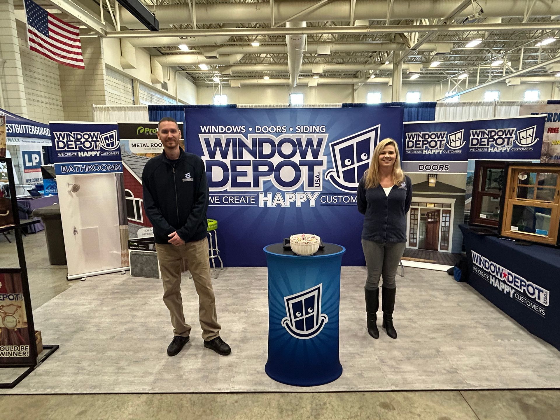 A man and a woman are standing in front of a window depot booth.