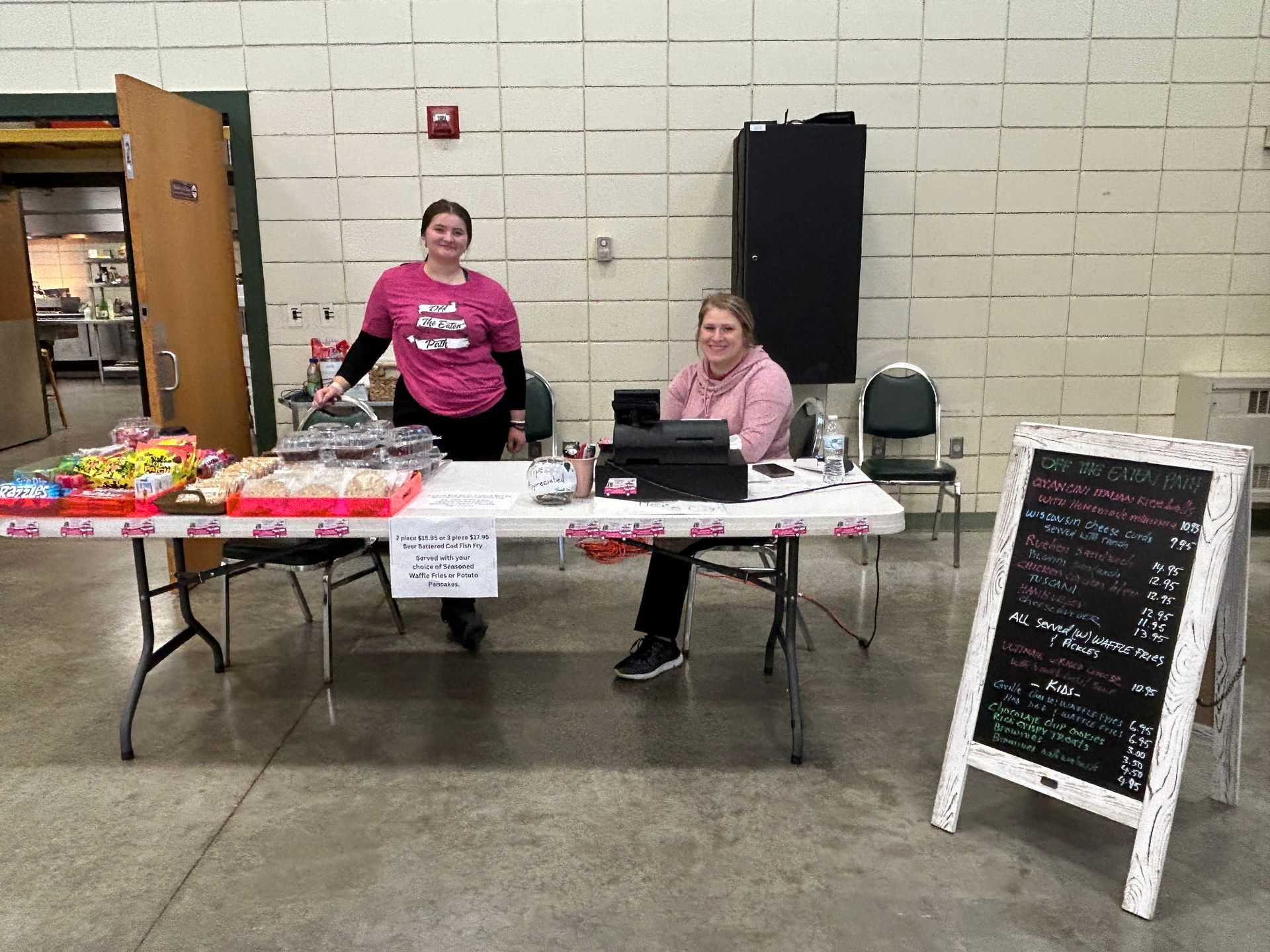 Two women are sitting at a table in a room.