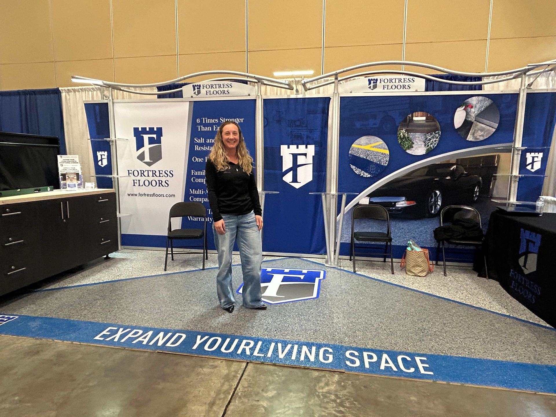 A woman is standing in front of a booth that says expand your living space