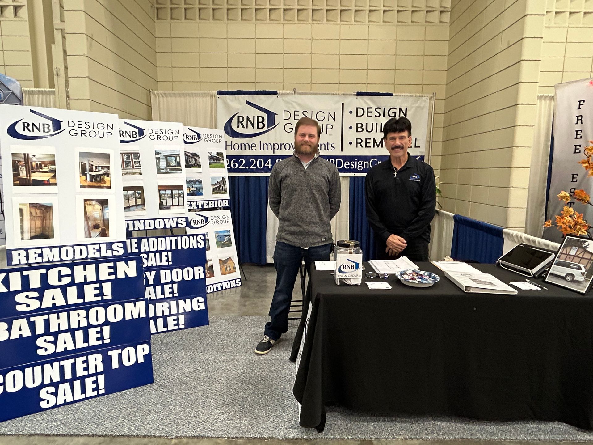 Two men standing in front of a table that says counter top sale
