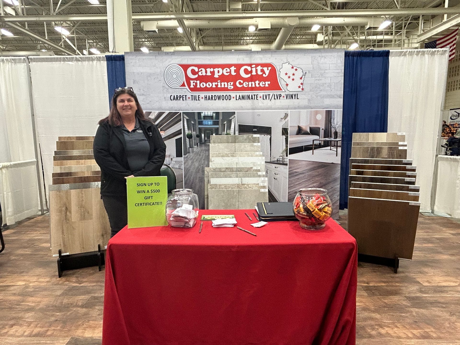A woman is standing in front of a table at a carpet city flooring center.