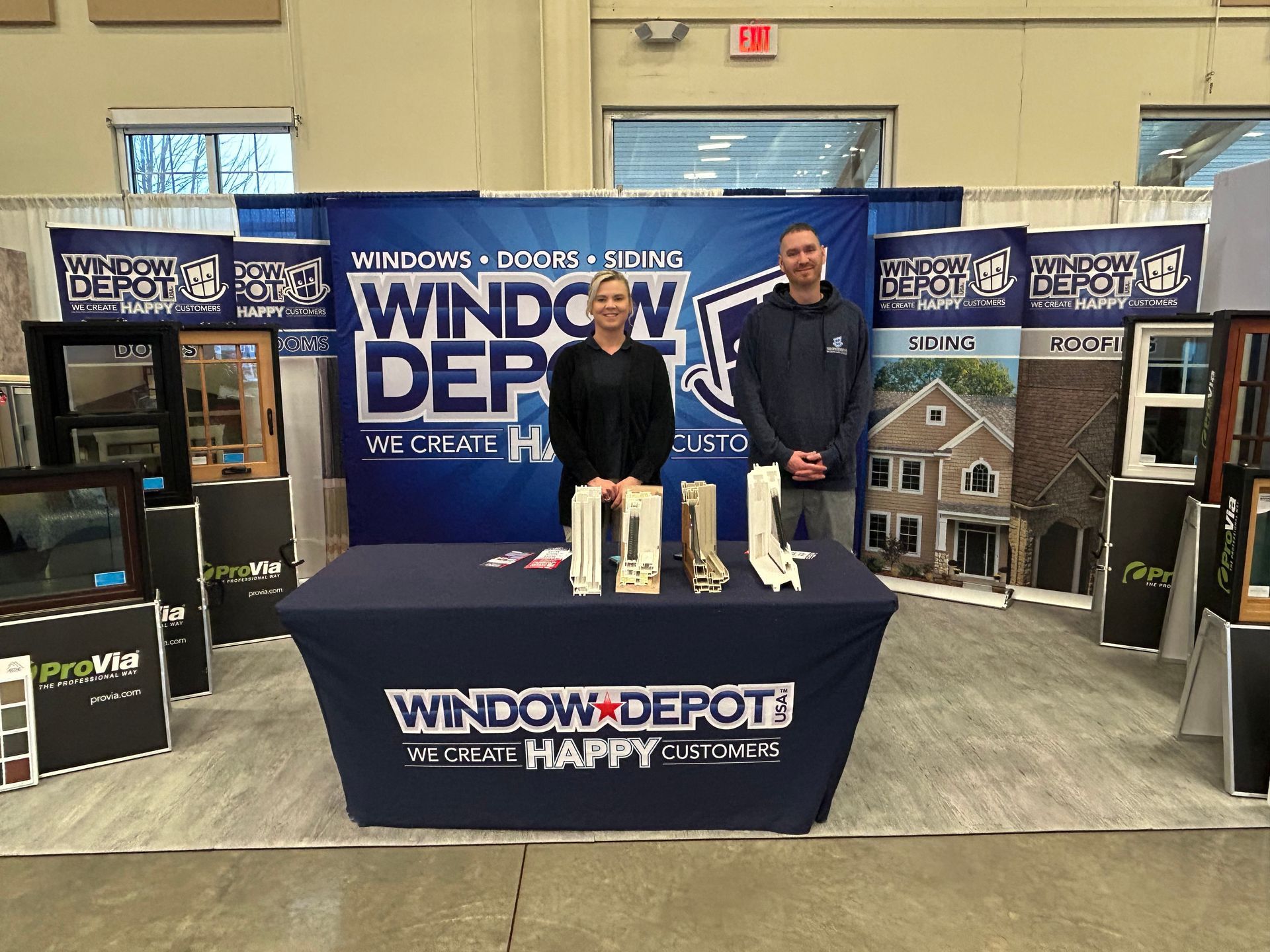 Two people standing in front of a window depot sign