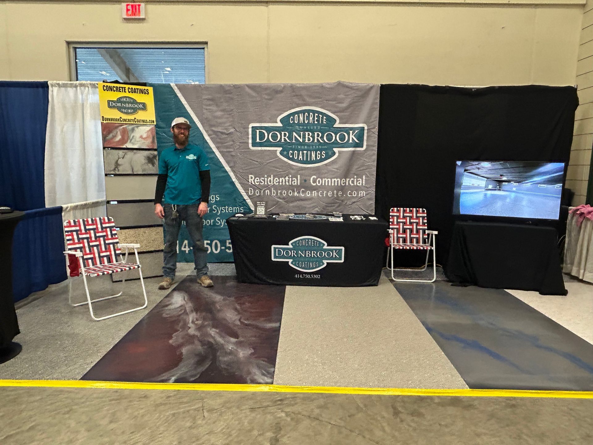 A man is standing in front of a booth at a trade show.