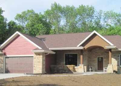 A house with a red siding and a brown roof