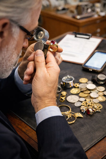 Man examining a detailed vase in a room filled with pottery, number 1.