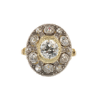 Diamond halo ring with a central diamond, surrounded by smaller diamonds, gold band.