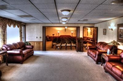 Interior of a funeral home with leather couches, neutral carpet, and a view into the chapel.