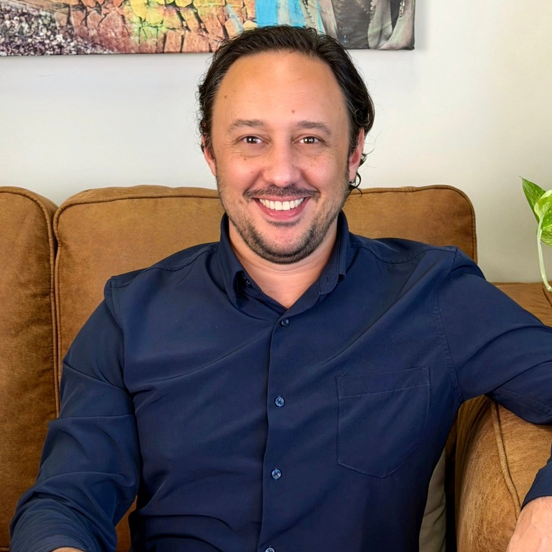 A man sitting on a couch smiling.