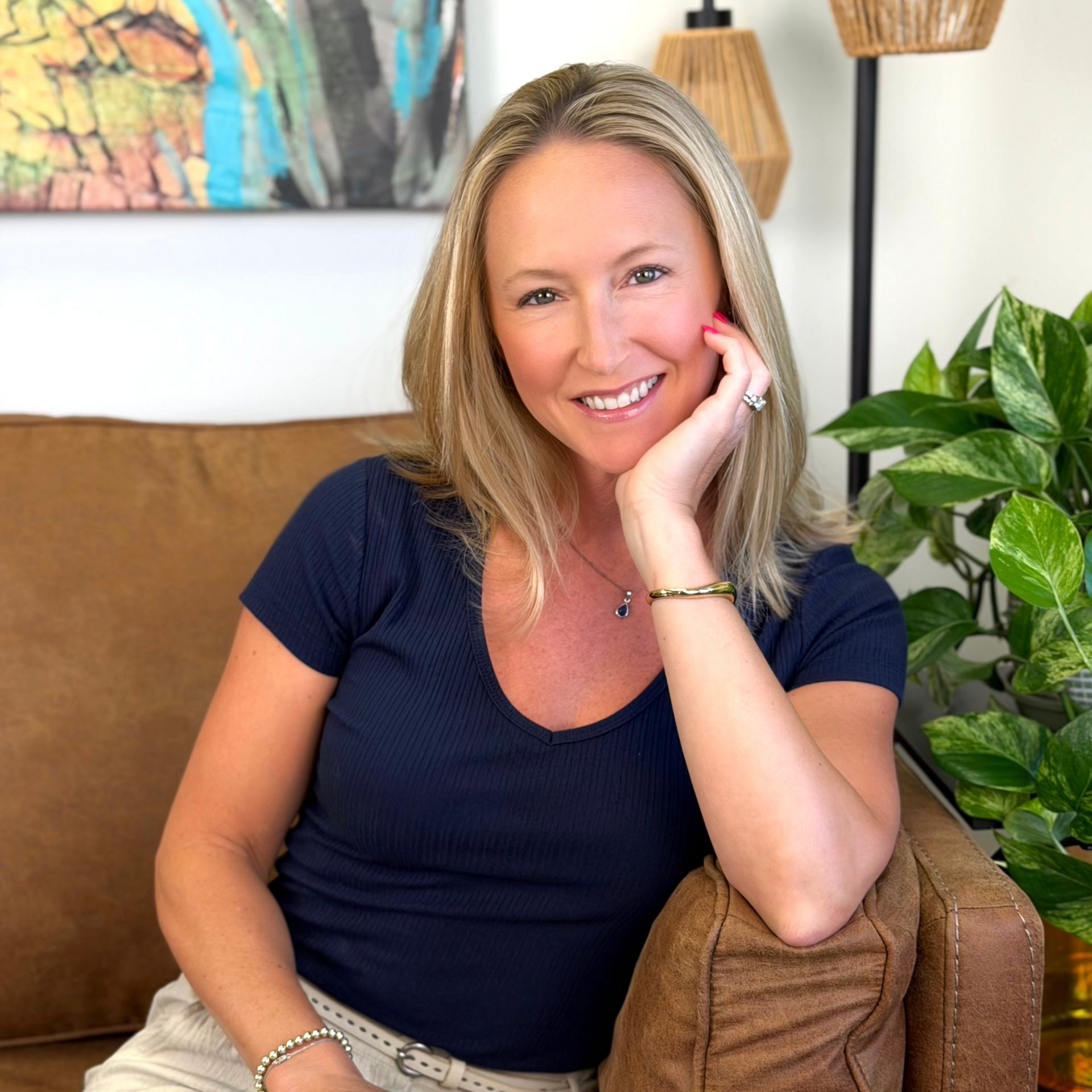 A woman sitting on a couch with face on her palm.