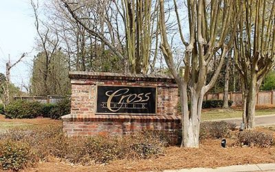 A brick neighborhood monument sign reading Cross Creek situated in a landscaped area with trees.