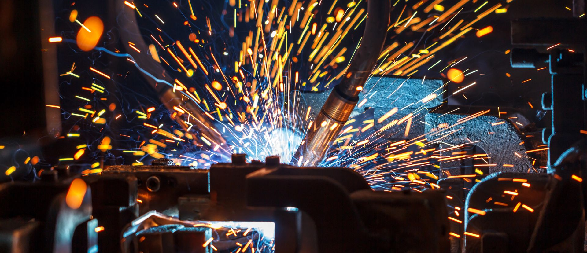 Robotic arms welding at an automotive manufacturing plant