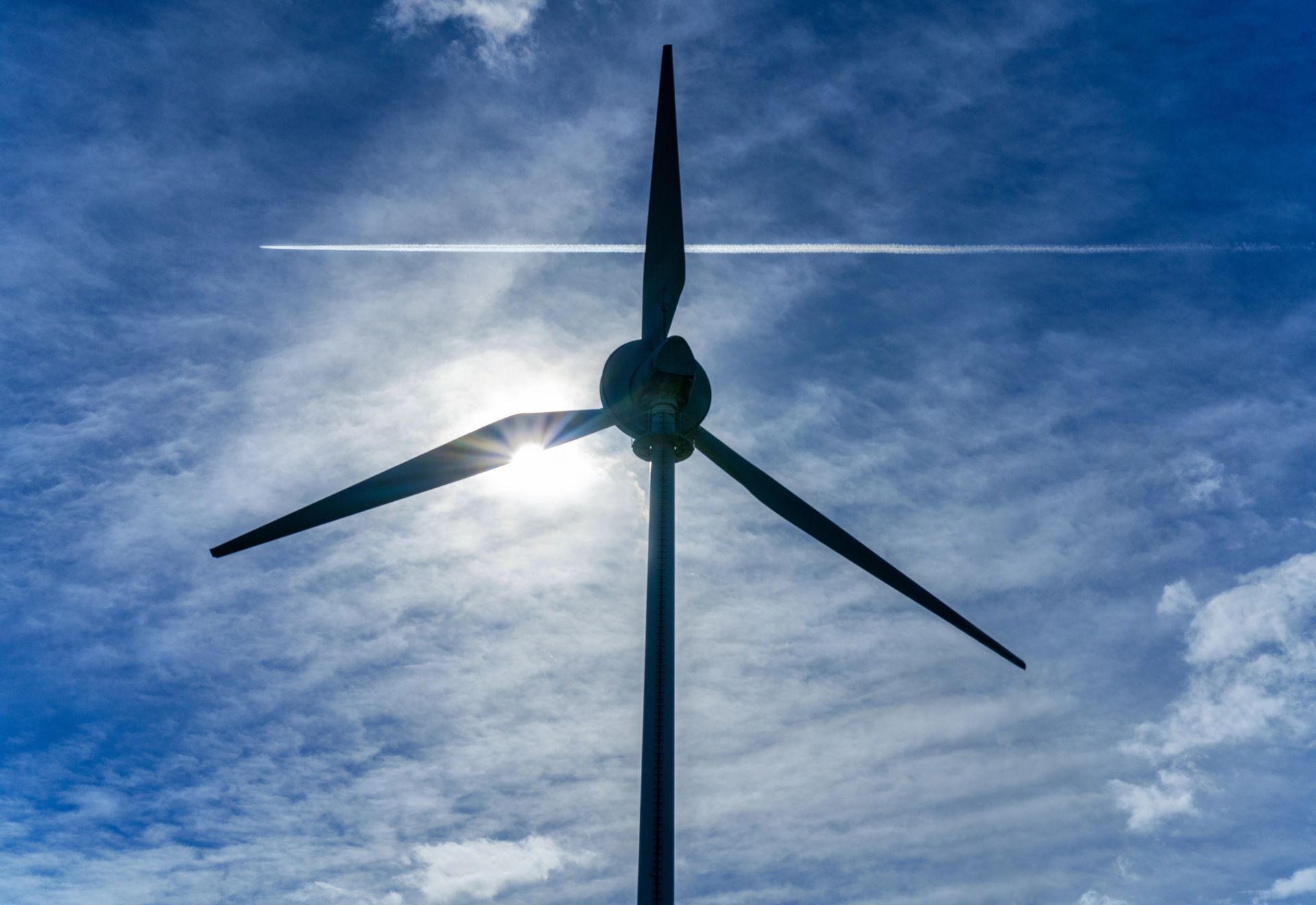 Wind turbine with airplane in back ground