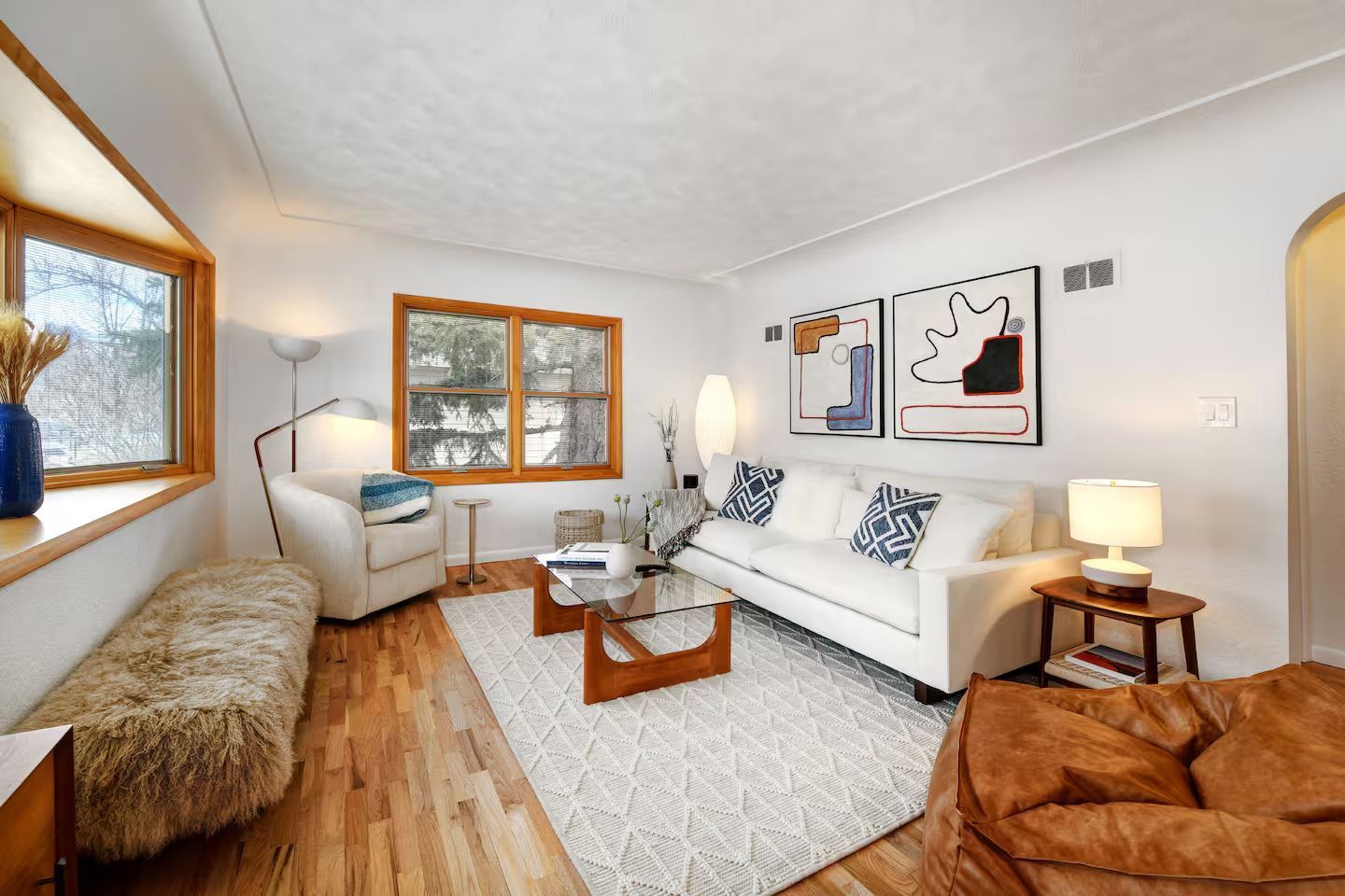 Two young women with backpacks smiling, entering a room from a doorway.
