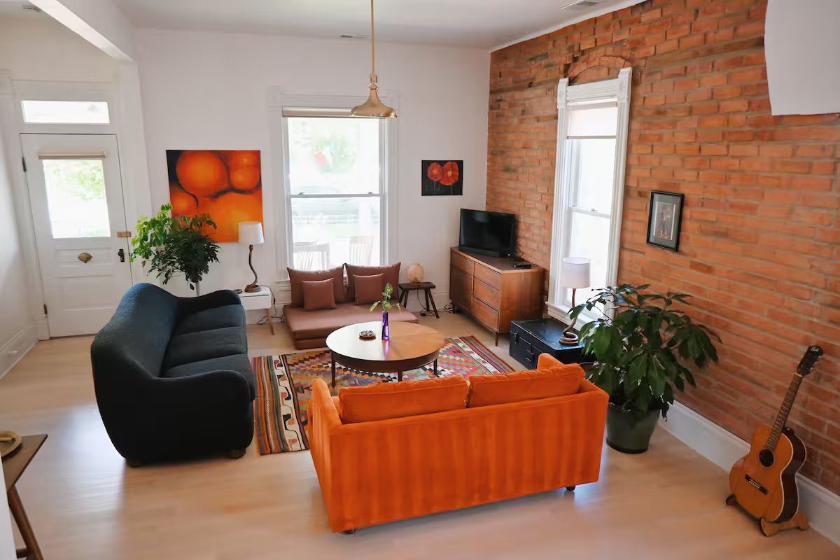 Two young women with backpacks smiling, entering a room from a doorway.