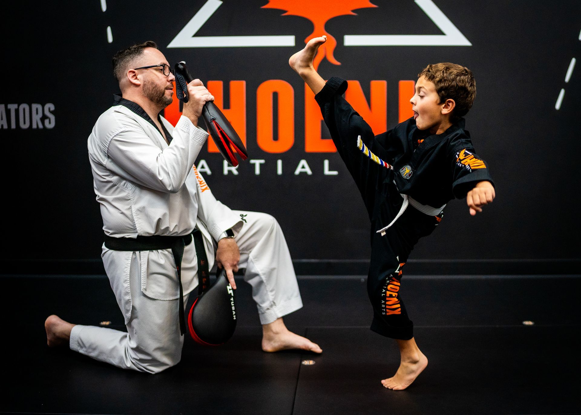 Child demonstrating a drop kick during a kids martial arts class at Phoenix Martial Arts in Murfreesboro, TN