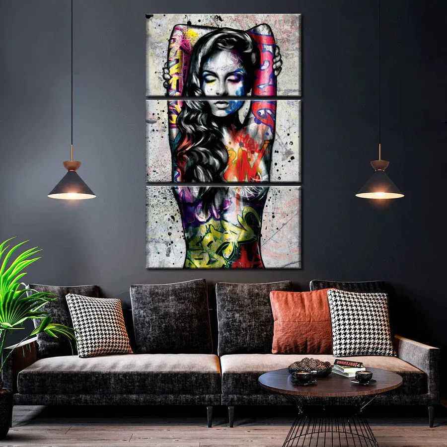 a living room with a couch and a painting of a woman on the wall .