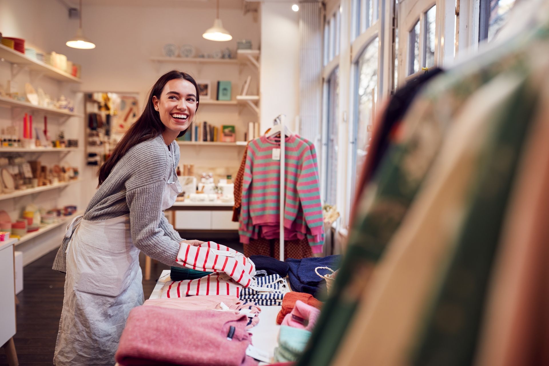 A woman is working in a clothing store.