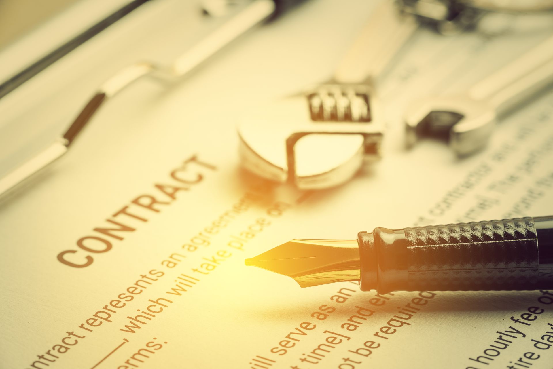 A fountain pen is sitting on top of a contract on a clipboard.