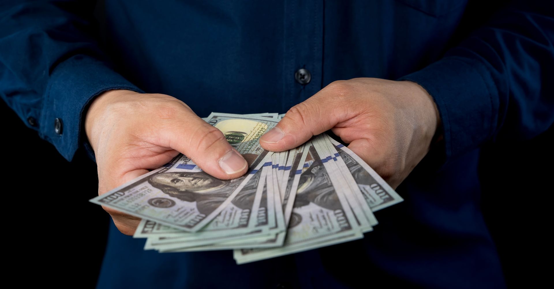 A man is holding a bunch of money in his hands.