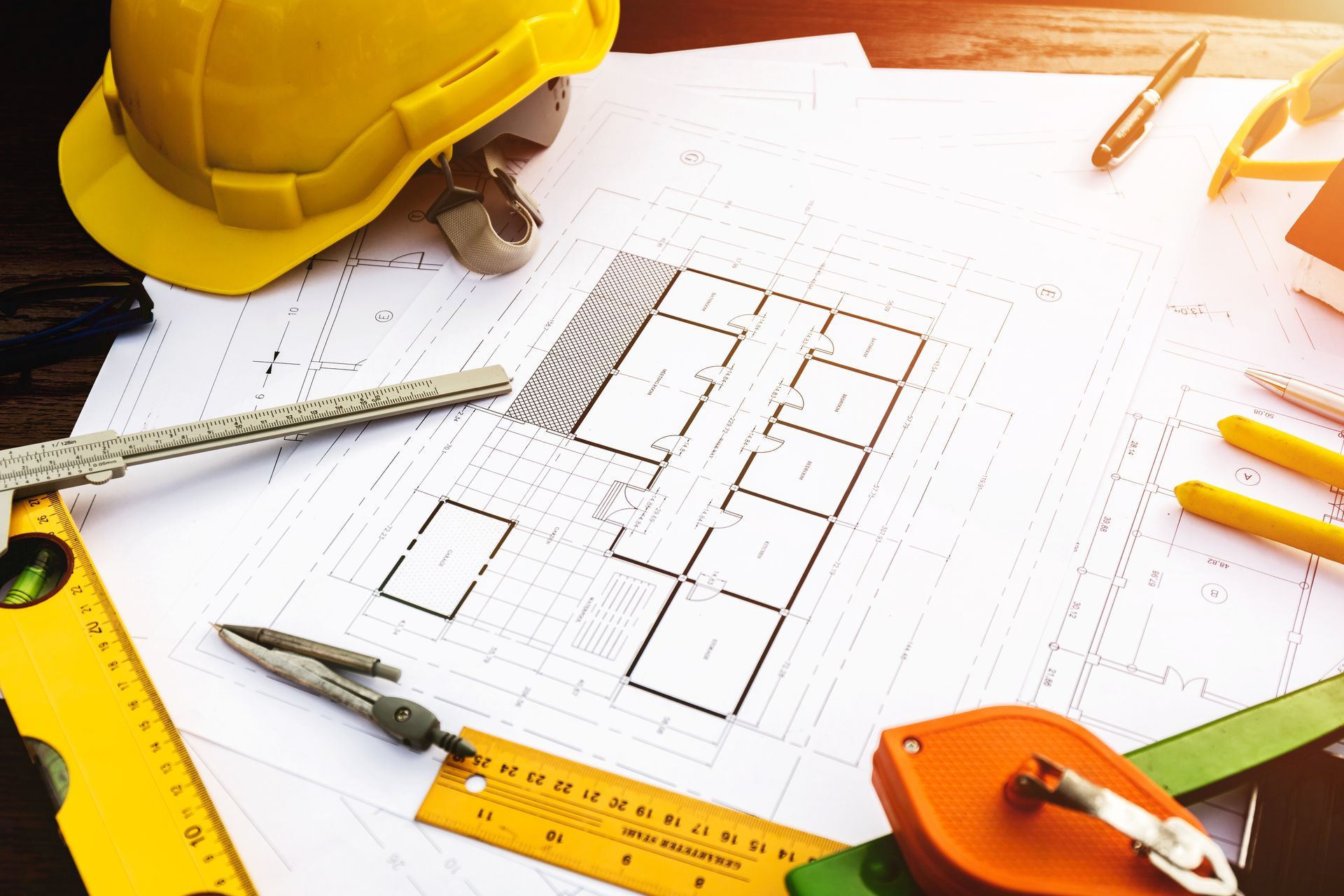 A hard hat is sitting on top of a blueprint on a table.