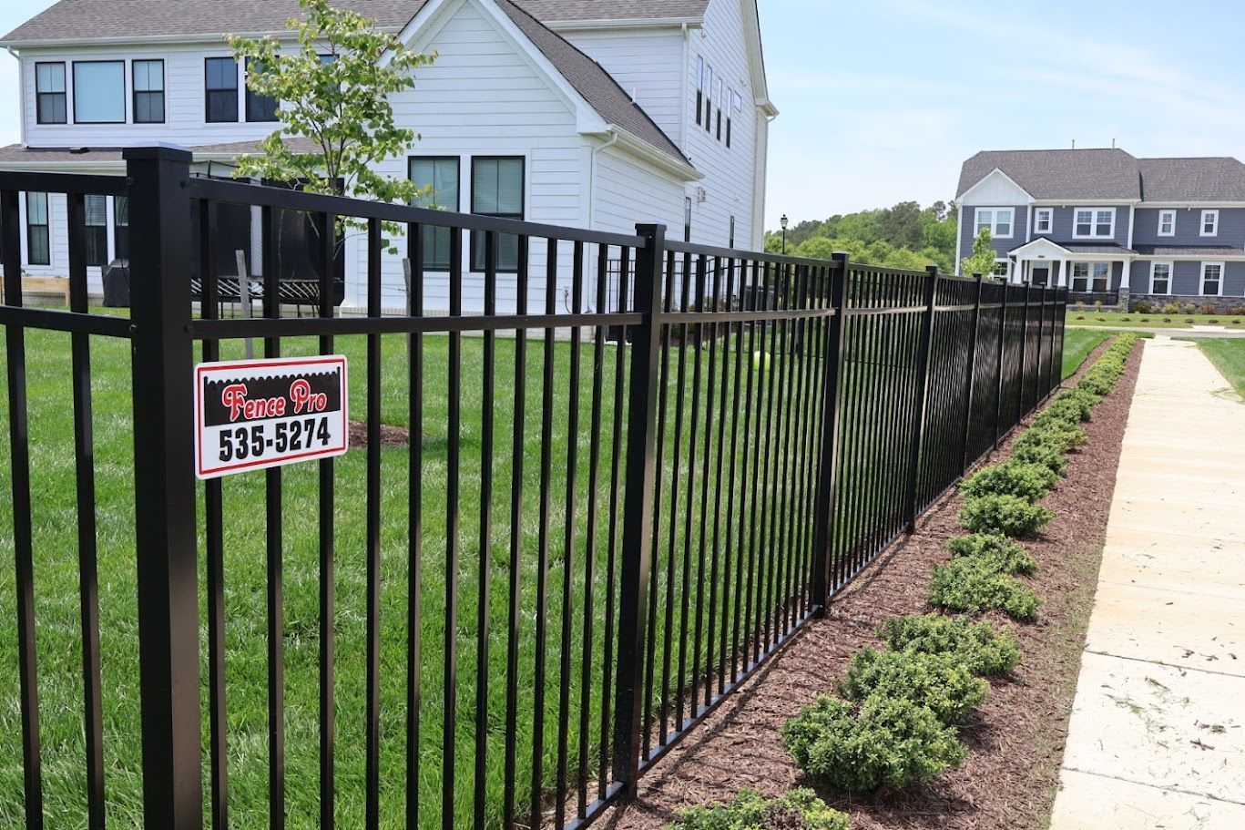 A black fence with a for sale sign on it