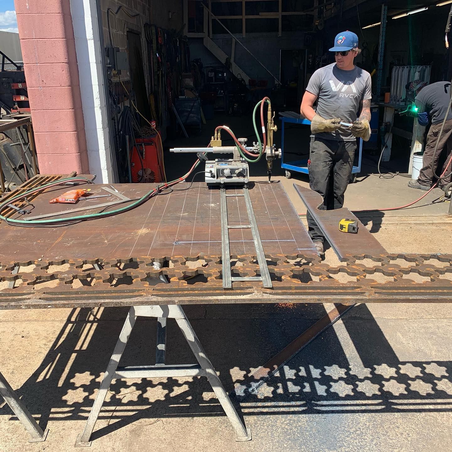 A man is working on a piece of metal in a garage