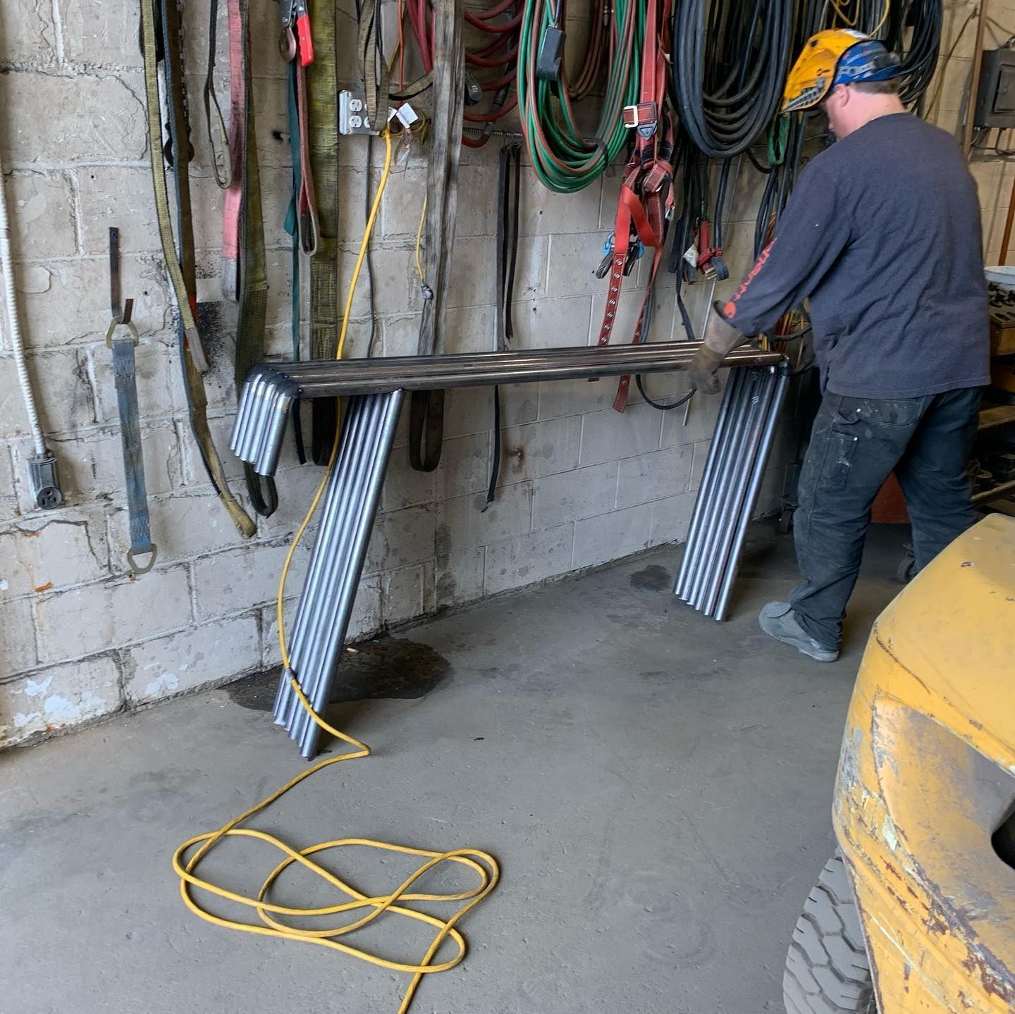 A man is working on a piece of metal in a garage