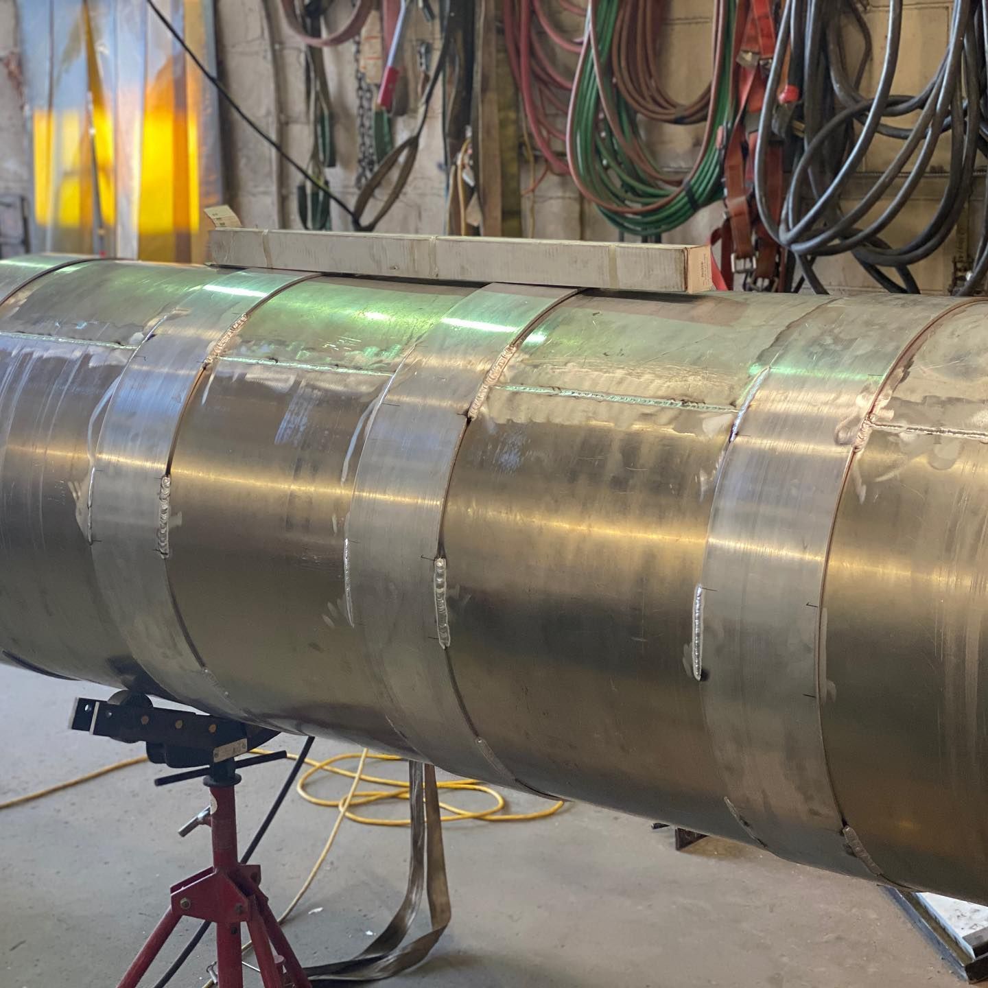 A large metal pipe is sitting on a red stand