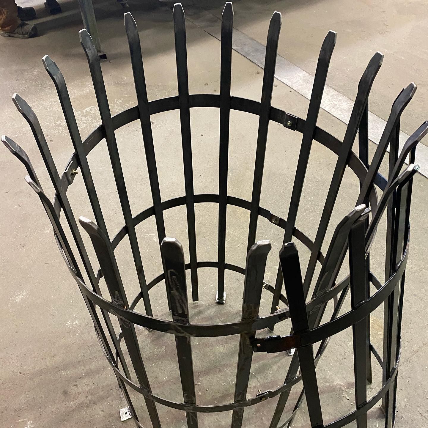 A wrought iron fence is sitting on a concrete floor.