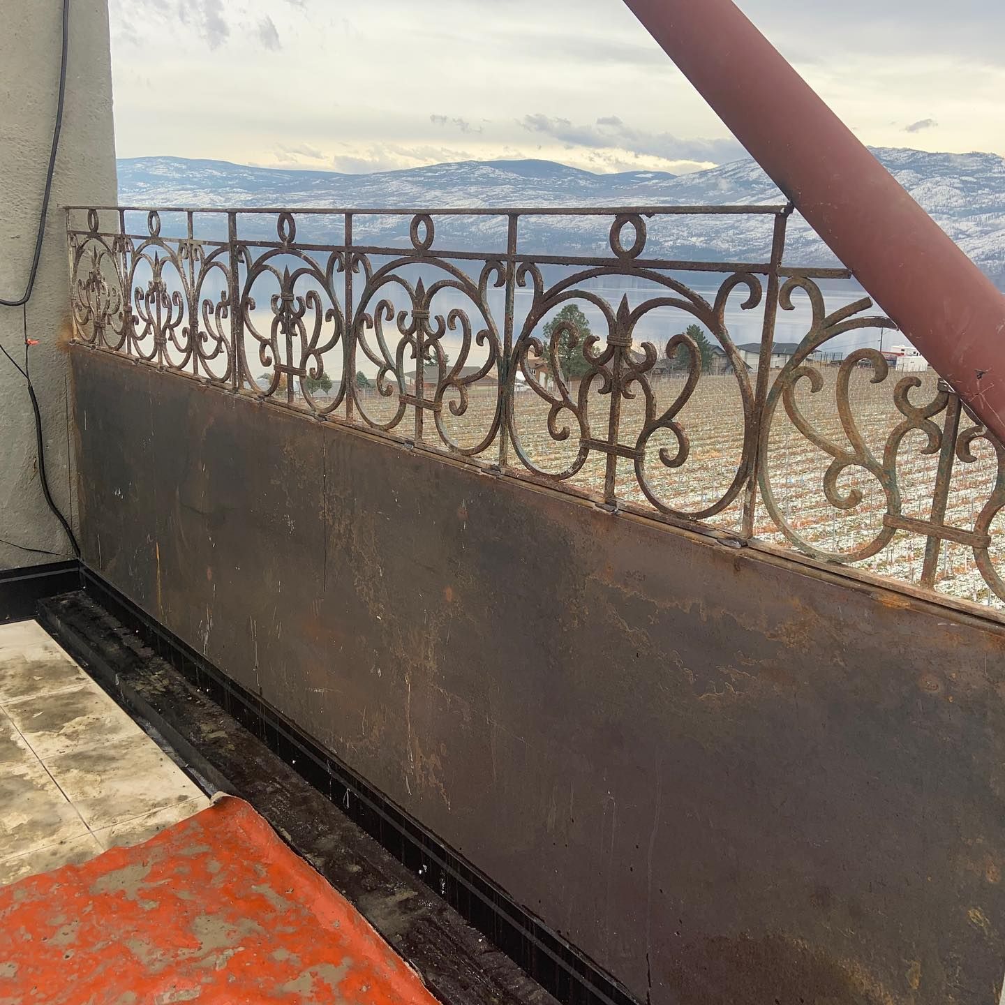 A balcony with a wrought iron railing and a view of the mountains