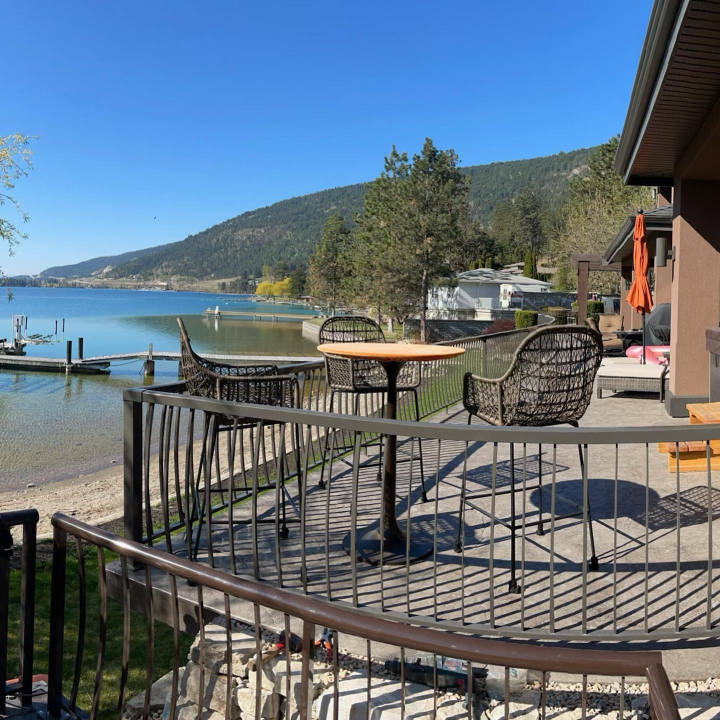A balcony overlooking a lake with tables and chairs