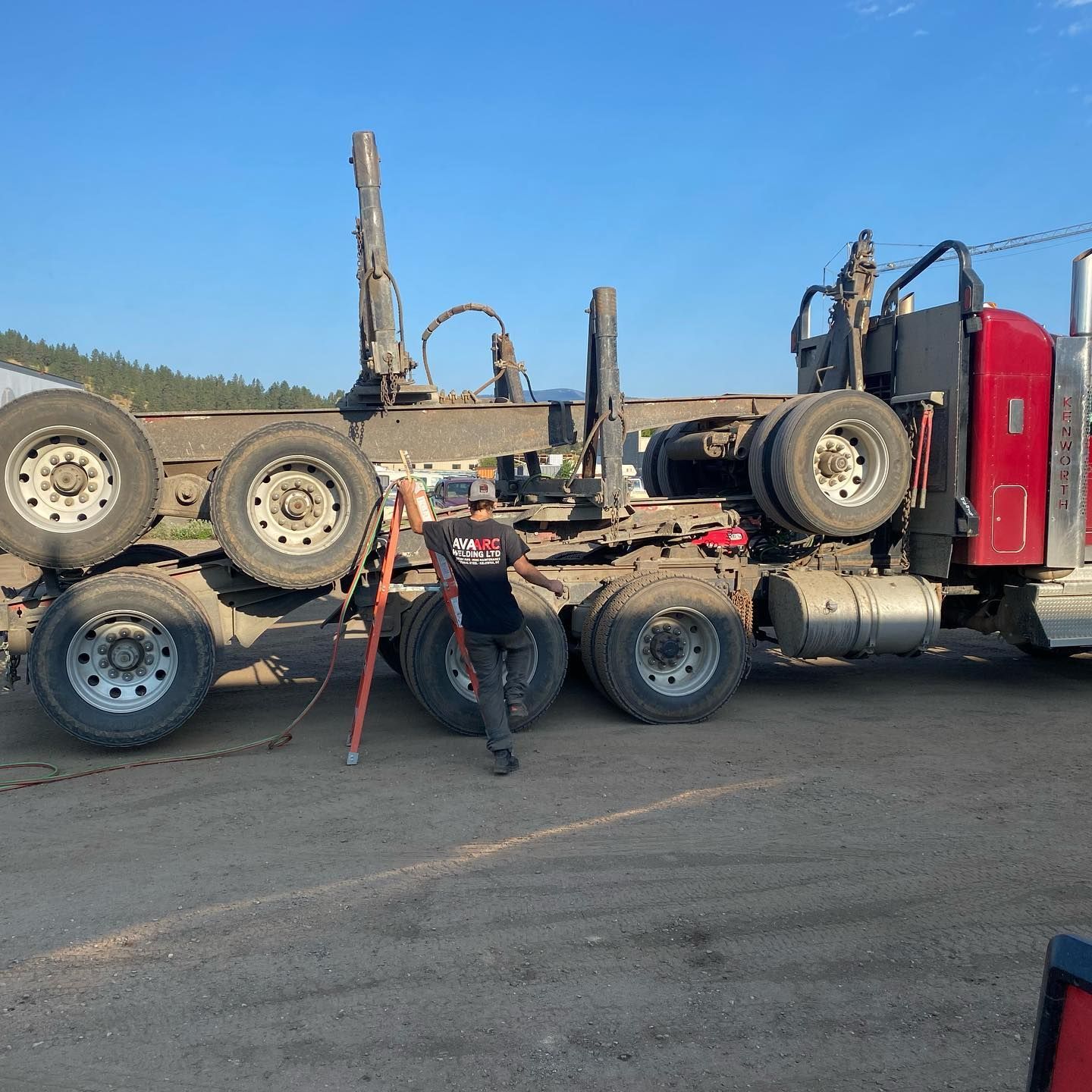 A man is standing in front of a large semi truck.