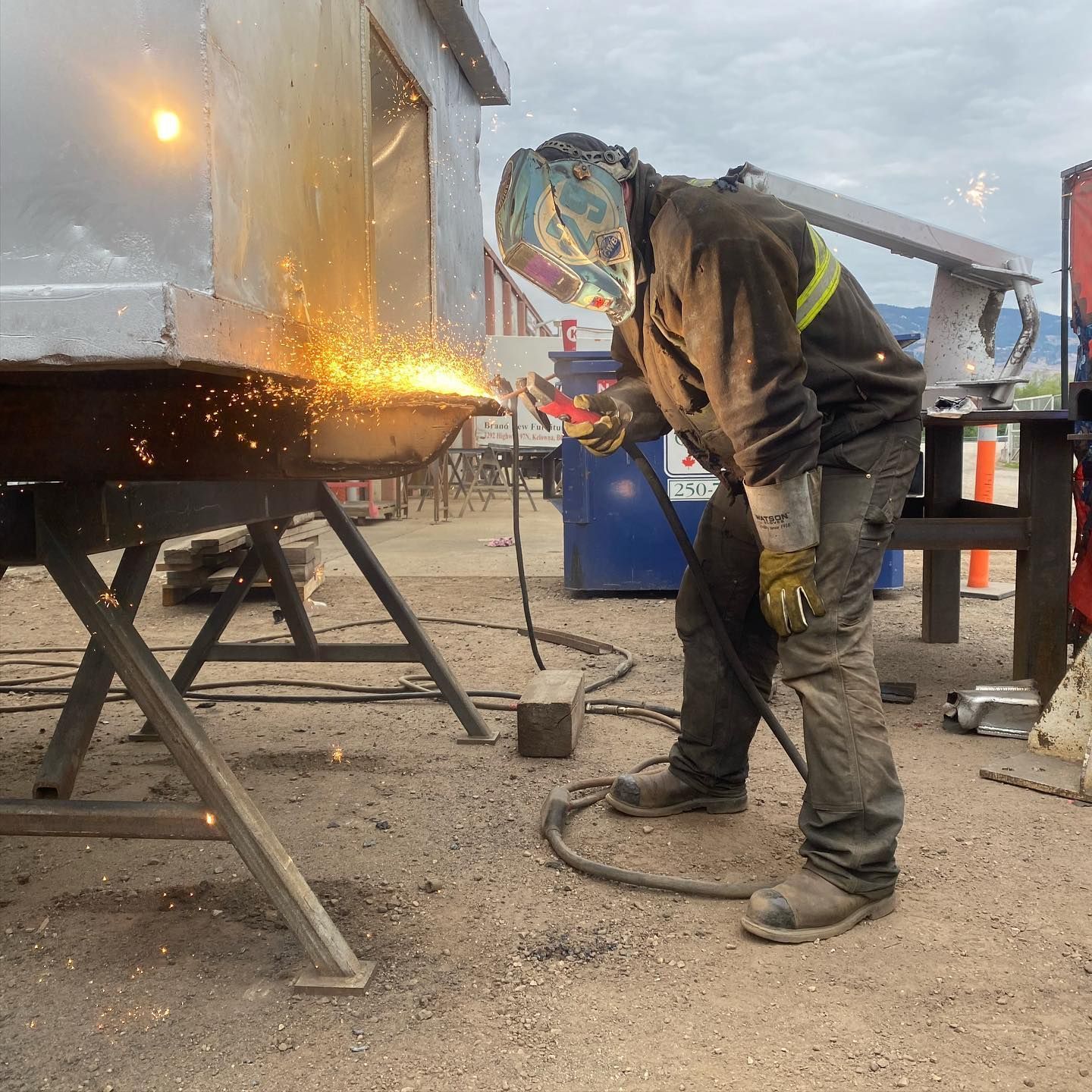 A man wearing a helmet is welding a piece of metal