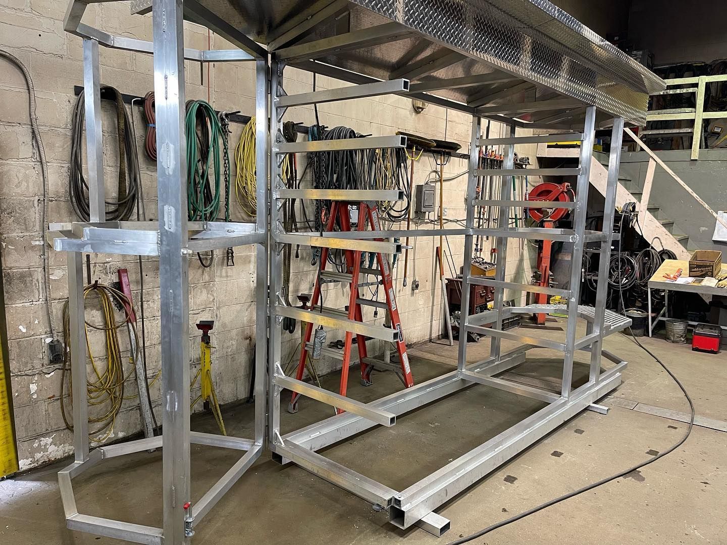 A metal structure is being built in a workshop.