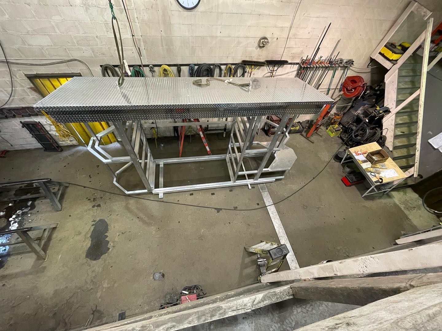A large piece of metal is hanging from the ceiling in a garage.
