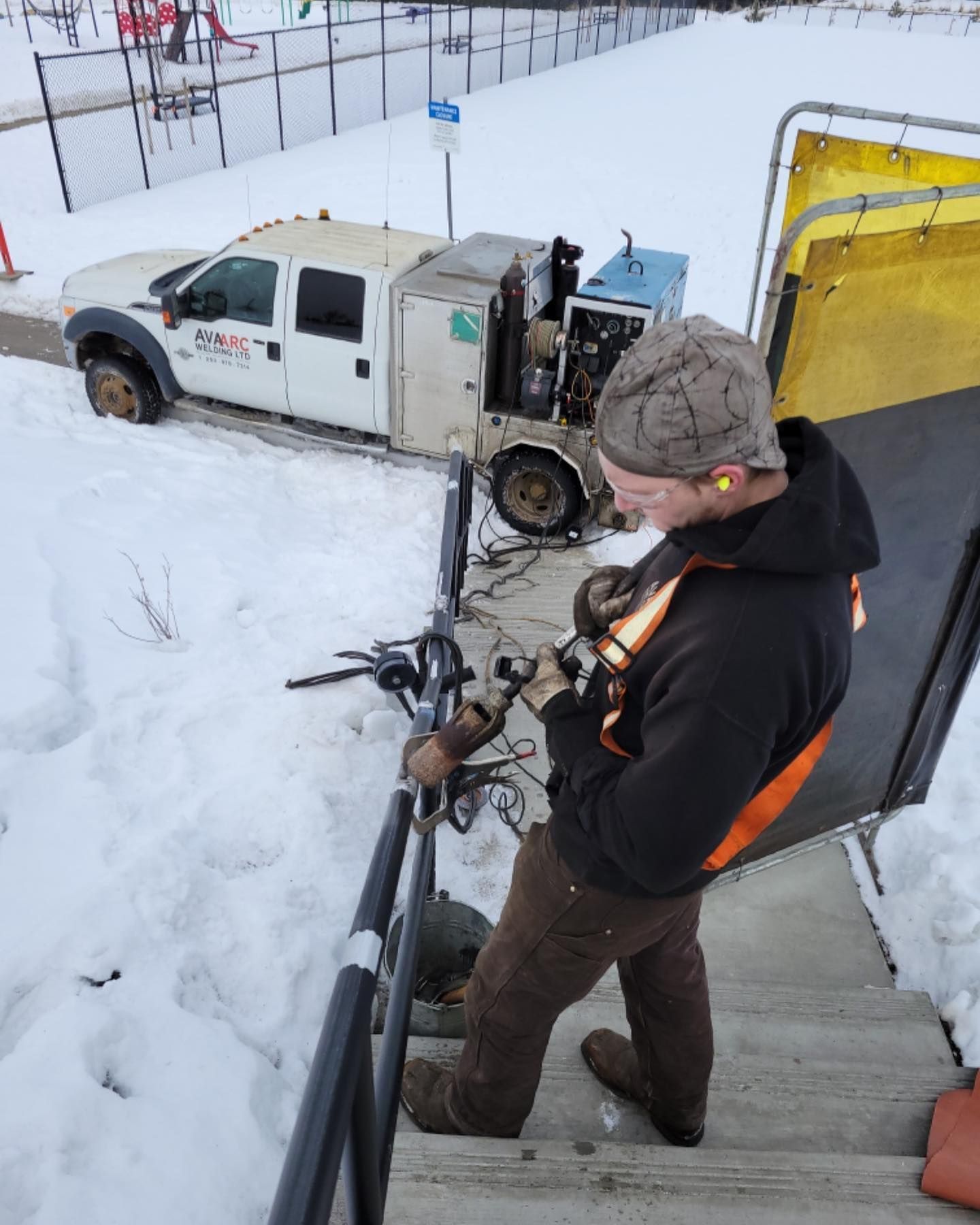 A man is standing on a set of stairs in front of a white truck that says dms
