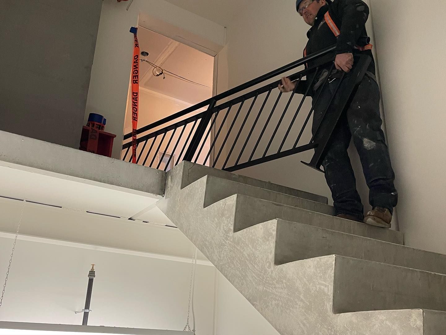 A man is standing on a set of stairs holding a railing.