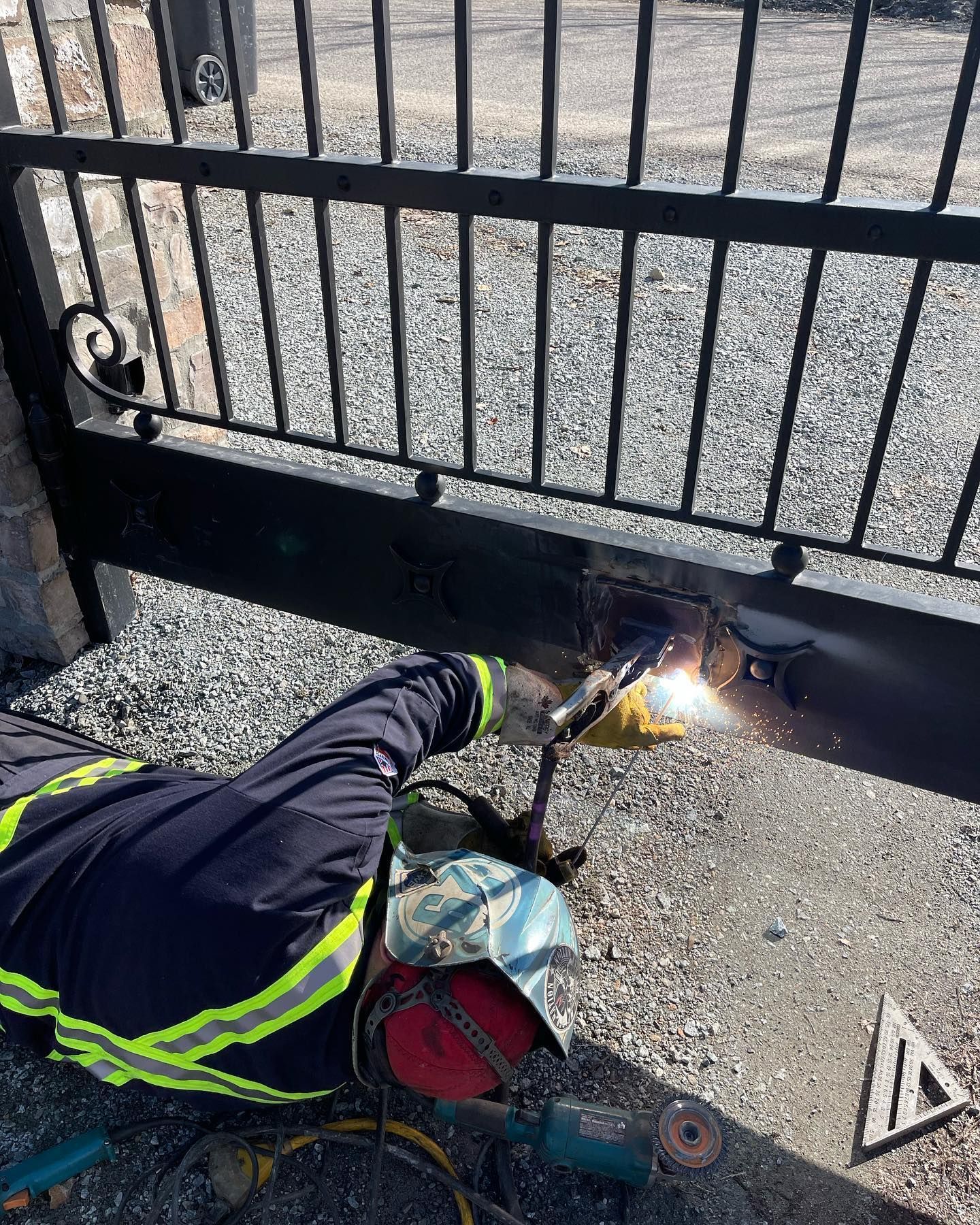 A man is welding a gate with a welding machine.