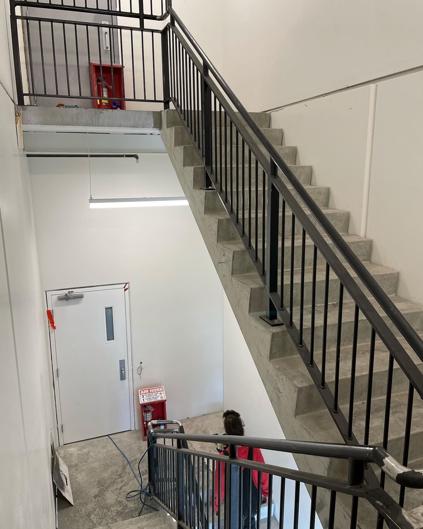 A staircase in a building with a metal railing